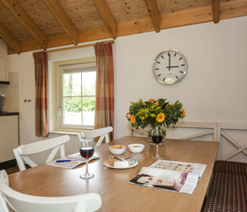 Een gezellige eethoek in een bungalow op Landal Twenhaarsveld, met een gedekte tafel en bloemen.