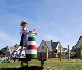 Kind speelt op een wipkip in de vorm van een vuurtoren in de speeltuin van vakantiepark Landal Vogelmient op Texel.