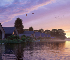 Watervilla's aan het water op Landal Waterresort Blocksyl tijdens een prachtige, kleurrijke zonsondergang.