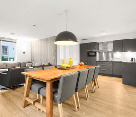 Modern interieur van de woonkamer en open keuken met een grote eettafel in een vakantiehuis op Landal Waufsberg.