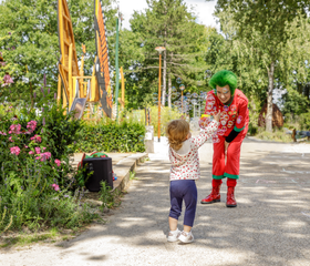 Een klein kindje geeft een high five aan de vrolijke, rode mascotte Orry in het vakantiepark Center Parcs Limburgse Peel.
