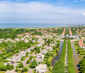 Een luchtfoto van het ruim opgezette Noordzee Résidence De Banjaard, met de luxe villa's en de ligging nabij het Noordzeestrand in Zeeland.