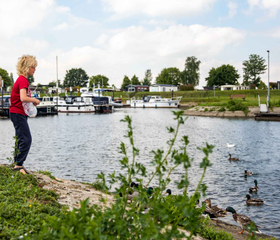 Kinderen kijken vanaf de kant naar de plezierjachten en bootjes die in de jachthaven van Recreatiepark Het Esmeer liggen.