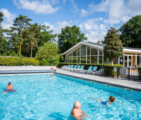 Het verwarmde buitenzwembad van Recreatiepark 't Gelloo op een zonnige dag.