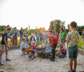 Kinderen zitten gezellig rondom een vuurkorf tijdens een georganiseerde buitenactiviteit op Residence Valkenburg.