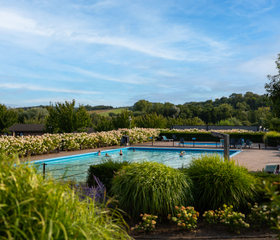 Het verwarmde buitenzwembad van Residence Valkenburg met een prachtig panoramisch uitzicht over de Limburgse heuvels.