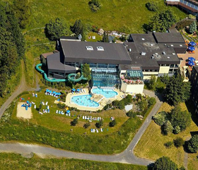 Luchtfoto van Rhön Park Aktiv Resort, met het grote buitenzwembad en de ligweide in het hart van het groene park.