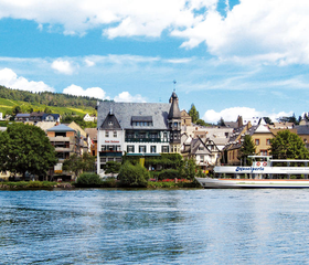 Uitzicht vanaf het water op Romantik Jugendstilhotel Bellevue en het stadje Traben-Trarbach aan de Moezel.