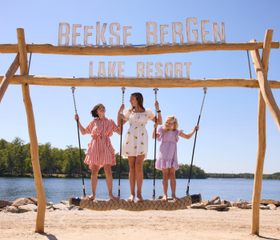 Meisjes poseren op de grote houten schommel bij het Victoriameer van Beekse Bergen Lake Reso