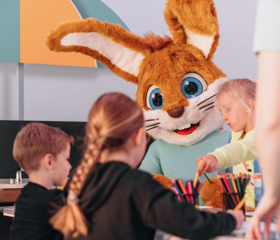 Kinderen knutselen en dansen gezellig met de mascotte Koos Konijn in de Kids Club van Vakantiepark Boomhiemke.