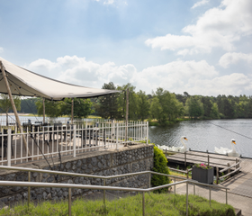 Het sfeervolle terras van het restaurant op Vakantiepark Bospark 't Wolfsven, gelegen direct aan het recreatiemeer.