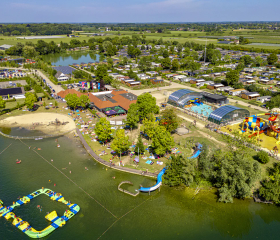 Grote luchtfoto van camping De Rotonde met het zwemmeer en de zwembaden