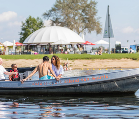 Gezin geniet van een boottocht in een sloep op de recreatieplas bij Vakantiepark Eiland van Maurik.