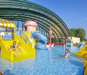 Het lichte binnenzwembad met glijbanen en waterspeelelementen