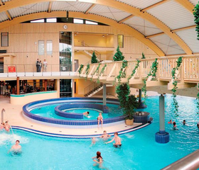 Het grote subtropische zwemparadijs Brockenbad op Vakantiepark Hasseröder, met een stroomversnelling en veel zwemmende gasten.