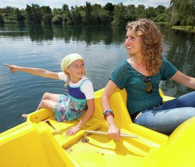 Moeder en kind op een gele waterfiets op het recreatiemeer van Vakantiepark Klein Vink in Arcen.