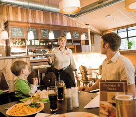 Een gezin met een jong kind bestelt eten in het gezellige restaurant van Landal Winterberg.
