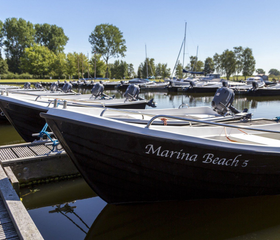 Motorboten van Marina Beach liggen aangemeerd in de jachthaven, klaar om het water op te gaan in Zeeland.