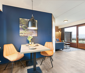 Sfeervol ingerichte eethoek en zithoek in een bungalow op Vakantiepark Reevallis in Limburg.