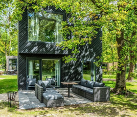 Een modern en luxe design vakantiehuis met twee verdiepingen, gelegen tussen de bomen op Vakantiepark Schaijk.