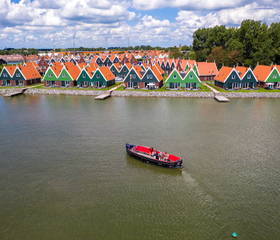 Luchtfoto van de kleurrijke huisjes van Vakantiepark Volendam, direct gelegen aan het water van het Markermeer.