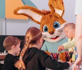 Kinderen knutselen gezellig samen met de vrolijke mascotte Koos Konijn bij de Kids Club van Vakantiepark Weerterbergen.
