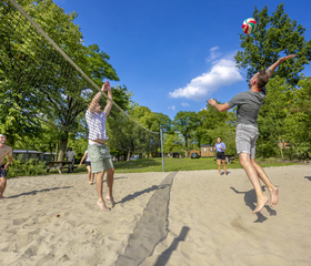 Jongeren spelen volleybal in het zand op het sportveld