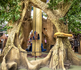 Kinderen spelen in een groot houten boomhut kermisattractie