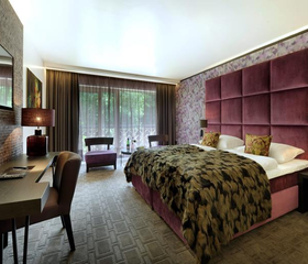 Een luxe en comfortabele hotelkamer in Van der Valk Gladbeck met een groot opgemaakt bed en een sfeervolle inrichting, ideaal voor families.