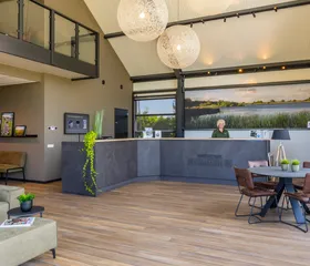 De ruime en lichte receptie en lounge van Waterpark Zwartkruis met een hoog plafond en modern interieur.