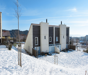 Een vakantiecottage van Center Parcs Park Hochsauerland, bedekt met sneeuw op een zonnige winterdag.