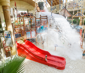Het Water Playhouse in het Aqua Mundo van Center Parcs Park Hochsauerland, waar een reusachtige emmer met 900 liter water omkiept boven de glijbanen.