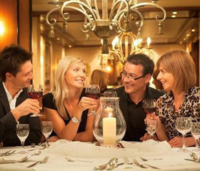Volwassenen genieten van een gezellig diner en proosten met elkaar in het sfeervolle restaurant van Göbels Landhotel.