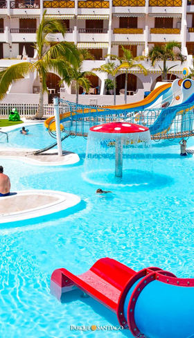 Het vrolijke kinderbad van Parque Santiago III op Tenerife met diverse kleine glijbanen en waterspeeltoestellen in het water.