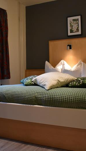 Moderne hotelkamer in Hotel Atlanta met een groen bed en een donkergrijze accentmuur