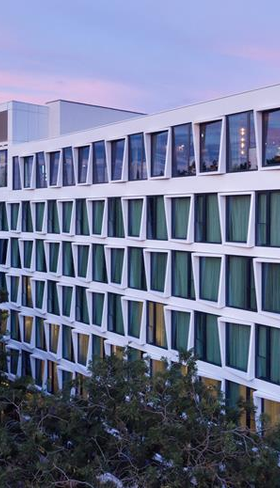 De moderne, witte buitenkant van het kindvriendelijke ATLANTIC Hotel Münster, een perfecte uitvalsbasis voor een familievakantie in de stad.
