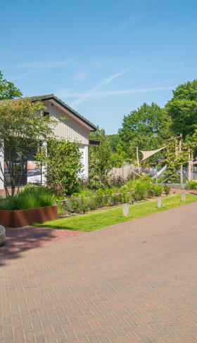 Hoofdgebouw en receptie van TopParken Bospark Ede met parkeerplaats