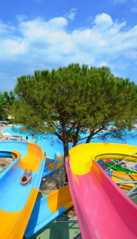 Kleurrijke waterglijbanen in het zwemparadijs van camping Bella Italia aan het Gardameer.