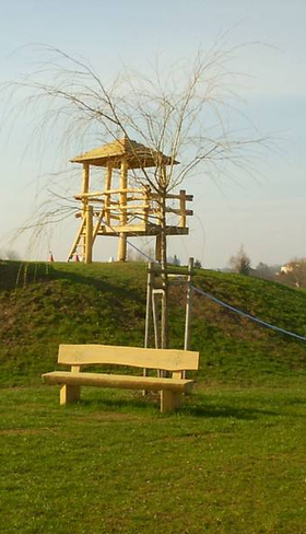 Grote speeltuin op een grasheuvel met een houten uitkijktoren en twee lange glijbanen op Knaus Campingpark Eschwege.