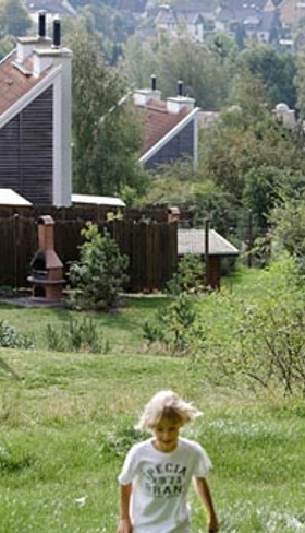 Kinderen spelen in de heuvelachtige, groene omgeving van Center Parcs Park Hochsauerland met de vakantiehuizen op de achtergrond.