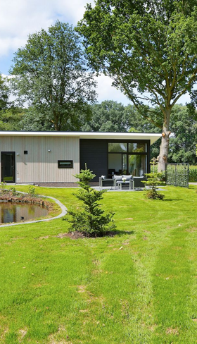 Moderne, vrijstaande vakantielodge op Vakantiepark De Lochemse Berg met een zeer ruime, groene tuin en een eigen vijver.