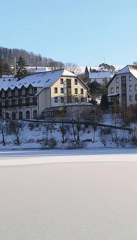 Het Göbels Seehotel, prachtig gelegen aan de bevroren Diemelsee in een winters landschap in Sauerland.
