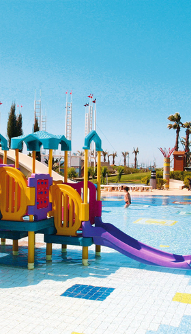 Het vrolijk gekleurde kinderbad met waterspeeltuin en kleine glijbaantjes bij hotel Pegasos World in Side, Turkije.