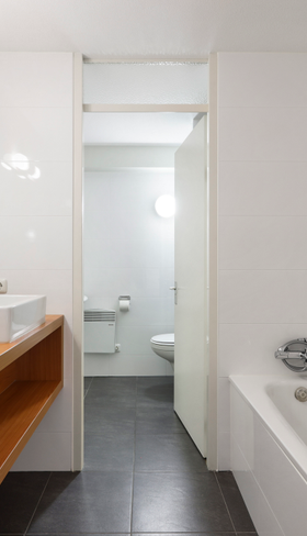 Moderne badkamer in een appartement van Landal Ameland State met dubbele wastafel, spiegel en een heerlijk ligbad om in te ontspannen.
