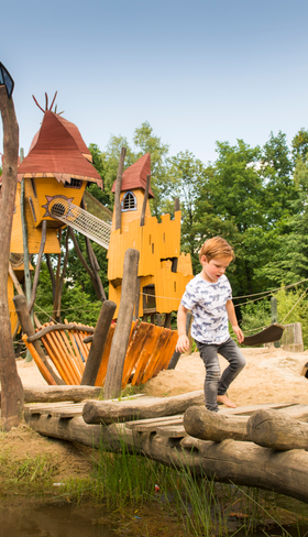 Kind speelt in de avontuurlijke buitenspeeltuin 'het Avonturenhof' op Landal Miggelenberg op de Veluwe.