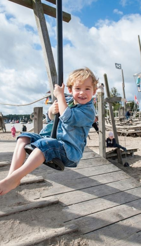 Een jongen zoeft van de kabelbaan in de speeltuin op het strand bij Landal Travemünde aan de Oostzee.