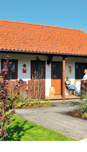 Overnachten in een gethematiseerd vakantiehuisje in het LEGOLAND Feriendorf bij LEGOLAND Deutschland in Beieren, met een grote LEGO piraat in de tuin.