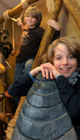 Twee lachende jongens poseren bij een Afrikaans standbeeld in het themahotel Matamba in attractiepark Phantasialand.