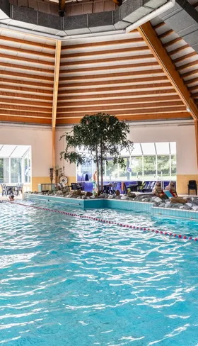 Het overdekte zwembad van Vakantiepark Port Greve in Zeeland, met een grote waterglijbaan en een apart peuterbad.
