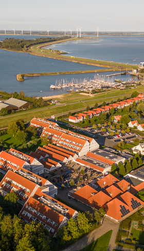 Luchtfoto van Vakantiepark Aquadelta, prachtig gelegen aan het Grevelingenmeer in Bruinisse, Zeeland, met de haven en vakantiehuizen.